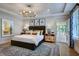 Comfortable main bedroom featuring a king-size bed, stylish light fixture, and access to a private porch at 219 George Hudson Rd, Siler City, NC 27344