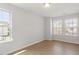 Sun-lit bedroom boasts hardwood-style flooring and large windows offering backyard views at 2211 Sweet Annie Way, Wake Forest, NC 27587