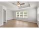 Bright bedroom features a tray ceiling, fan, and plenty of natural light from three large windows at 2211 Sweet Annie Way, Wake Forest, NC 27587
