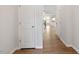 Bright hallway with wood floors, white walls, and doors leading to other areas of the home at 2211 Sweet Annie Way, Wake Forest, NC 27587