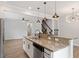Open kitchen with granite countertops, stainless steel appliances, pendant lights, and view to adjacent living area at 2211 Sweet Annie Way, Wake Forest, NC 27587
