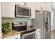 Modern kitchen featuring stainless steel appliances, granite countertops, and sleek white cabinets with dark hardware at 2211 Sweet Annie Way, Wake Forest, NC 27587