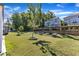 Spacious backyard featuring a well-maintained lawn, trees and retaining wall at 2217 Holtwood Way, Apex, NC 27523