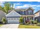 Charming two-story home with stone accents, red shutters, landscaped yard, and a two-car garage at 2217 Holtwood Way, Apex, NC 27523