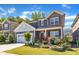 Charming two-story home with stone accents, red shutters, landscaped yard, and a two-car garage at 2217 Holtwood Way, Apex, NC 27523