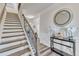 Elegant foyer with hardwood stairs, decorative mirror, and stylish console table with floral arrangements at 2217 Holtwood Way, Apex, NC 27523