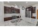 Close up of kitchen island with granite countertop, stainless steel sink and faucet, and stylish lighting fixtures at 2217 Holtwood Way, Apex, NC 27523