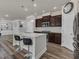Well-lit kitchen with central island, stylish dark cabinetry, stainless appliances, and hardwood floors at 2217 Holtwood Way, Apex, NC 27523