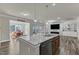 Open-concept kitchen with center island, stainless appliances, and view into the dining and living areas at 2217 Holtwood Way, Apex, NC 27523