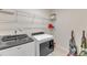 Functional laundry room with washer, dryer, wire shelving and tile flooring at 2217 Holtwood Way, Apex, NC 27523
