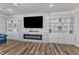 Bright living room features built-in shelving, modern fireplace, hardwood floors, and comfortable seating at 2217 Holtwood Way, Apex, NC 27523