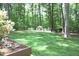 Lush green backyard showing grass lawn and flower planters at 2603 Red Pine Rd, Hillsborough, NC 27278