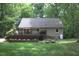 Exterior view of home with deck, surrounded by green lawn with flower planters at 2603 Red Pine Rd, Hillsborough, NC 27278