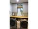 Efficient laundry room with a wooden countertop, storage cabinets, and modern washer and dryer at 2603 Red Pine Rd, Hillsborough, NC 27278