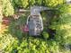 Aerial view of a home with a long driveway, surrounded by lush greenery and trees at 2616 Dockery Ln, Raleigh, NC 27606