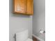 Small half bathroom with a white toilet, wood cabinets, and modern fixtures at 2616 Dockery Ln, Raleigh, NC 27606