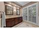 Bathroom showcasing double vanity with granite countertops and a window with plantation shutters at 2616 Dockery Ln, Raleigh, NC 27606