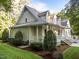 Well-maintained home exterior featuring a covered porch, lush landscaping, and manicured lawn at 2616 Dockery Ln, Raleigh, NC 27606