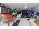 Entertainment room featuring multiple pinball machines, a TV, and a comfortable black leather loveseat at 2616 Dockery Ln, Raleigh, NC 27606