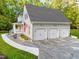 Spacious three-car garage featuring white doors, exterior lights, and neutral paint color, adding to the home's functionality at 2616 Dockery Ln, Raleigh, NC 27606