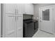 Convenient laundry room with sleek washer and dryer and ample white storage cabinets at 2616 Dockery Ln, Raleigh, NC 27606