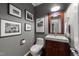 Elegant powder room boasts framed artwork, a wooden vanity, and a modern white toilet at 2616 Dockery Ln, Raleigh, NC 27606