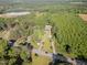 Expansive aerial view of a wooded property with mature trees, road frontage, and multiple structures at 2670 Nc 210 S, Lillington, NC 27546