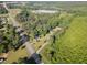 Aerial view of the property showcasing the home, shed, road, and surrounding trees at 2670 Nc 210 S, Lillington, NC 27546