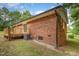 Back of brick home featuring a small deck and grassy yard at 2670 Nc 210 S, Lillington, NC 27546