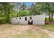 Exterior view of manufactured home with simple landscaping and mature trees surrounding the property at 2670 Nc 210 S, Lillington, NC 27546