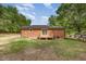 Back of brick home featuring a small deck and a grassy lawn at 2670 Nc 210 S, Lillington, NC 27546