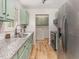 Recently renovated kitchen featuring light green cabinets, stainless steel appliances, and granite countertops at 2670 Nc 210 S, Lillington, NC 27546