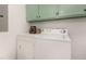 Bright laundry area with shelving above the washer and dryer at 2670 Nc 210 S, Lillington, NC 27546