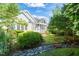 Landscaped backyard featuring lush greenery, a small creek, and stone accents at 2720 Snowy Meadow Ct, Raleigh, NC 27614