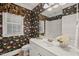 Stylish bathroom with unique floral wallpaper, white vanity, and bright lighting at 2720 Snowy Meadow Ct, Raleigh, NC 27614