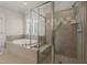 Luxurious bathroom with soaking tub, glass shower, and neutral tile surround at 2720 Snowy Meadow Ct, Raleigh, NC 27614