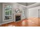 Living room with a cozy fireplace, large windows and gleaming hardwood floors at 2720 Snowy Meadow Ct, Raleigh, NC 27614