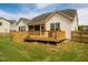 Back exterior view of house with a deck and a lush green backyard at 2910 Reynolda Cir, Durham, NC 27712