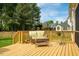 Backyard wooden deck features outdoor furniture, flowers, and view of yard and neighborhood at 2910 Reynolda Cir, Durham, NC 27712