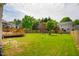 A sprawling backyard featuring a wooden deck, lush greenery, and a privacy fence at 2910 Reynolda Cir, Durham, NC 27712