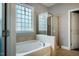 This bathroom features soaking tub, glass enclosed shower, tile surround, and a window at 2910 Reynolda Cir, Durham, NC 27712