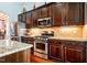 Modern kitchen with granite counters, stainless appliances, and rich wood cabinetry at 2910 Reynolda Cir, Durham, NC 27712