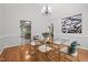 Dining room boasts a glass table, gold chairs, hardwood floors and contemporary artwork at 2917 Kesler Trl, Mebane, NC 27302