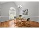 Bright dining room featuring hardwood floors, modern chandelier, and a glass table set at 2917 Kesler Trl, Mebane, NC 27302