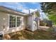 View of the house's back exterior with a small, unkept yard and patio at 3027 Maple Ave # M2, Burlington, NC 27215