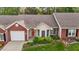 Beautiful brick and siding home featuring lush landscaping and a lovely red door at 3027 Maple Ave # M2, Burlington, NC 27215