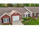 Aerial view of a charming brick and siding home with well-manicured landscaping and driveway at 3027 Maple Ave # M2, Burlington, NC 27215