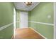 Hallway with green walls, hardwood floors, white trim, and elegant chandelier at 3027 Maple Ave # M2, Burlington, NC 27215