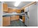 Traditional kitchen featuring wooden cabinets, a black range, and a modern stainless steel refrigerator at 3027 Maple Ave # M2, Burlington, NC 27215