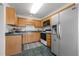 Traditional kitchen with oak cabinets, a black microwave, and a stainless steel refrigerator at 3027 Maple Ave # M2, Burlington, NC 27215
